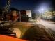 Nighttime view of a grassy backyard with a wood fence and the lights of the adjacent buildings in the distance at 1074 Hobson Sw St, Atlanta, GA 30310