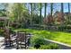 Landscaped backyard with brick patio, wood rocking chairs and a lush green lawn at 5452 Tally Green Dr, Marietta, GA 30068