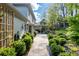 Stone patio with a paved path, bordered by manicured shrubs and mature trees at 5452 Tally Green Dr, Marietta, GA 30068