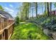 Grassy backyard area with stone retaining wall, lush lawn, and privacy fence at 5452 Tally Green Dr, Marietta, GA 30068