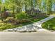 Beautiful two-story brick home with mature trees, manicured landscaping, and a long driveway, creating curb appeal at 5452 Tally Green Dr, Marietta, GA 30068