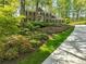 Charming brick home with lush landscaping, stone accents and mature trees offering a picturesque setting at 5452 Tally Green Dr, Marietta, GA 30068