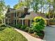 Two-story brick home with lush landscaping, a stone walkway, and mature trees creates a serene and inviting ambiance at 5452 Tally Green Dr, Marietta, GA 30068
