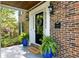 Elegant brick facade with a charming front porch, potted plants, and stylish lighting at 5452 Tally Green Dr, Marietta, GA 30068