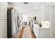 Modern galley kitchen with white cabinets, stainless steel appliances, and hardwood floors at 5452 Tally Green Dr, Marietta, GA 30068