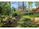 Beautifully landscaped backyard with a stone pathway winding through lush greenery and mature trees at 5452 Tally Green Dr, Marietta, GA 30068