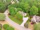 Aerial view showcases a luxurious home with mature landscaping in a serene, wooded setting at 5705 Twelve Oaks Dr, Cumming, GA 30028