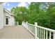 Wide back deck of the home, with a white railing, that overlooks the lush green trees at 5705 Twelve Oaks Dr, Cumming, GA 30028