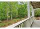 Covered back deck area overlooks the green, grassy backyard with the trees surrounding it at 5705 Twelve Oaks Dr, Cumming, GA 30028