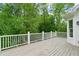 Wood deck with white railings overlooks a tranquil setting of mature green trees at 5705 Twelve Oaks Dr, Cumming, GA 30028