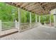 Covered back deck area with wooden flooring overlooks the luscious backyard at 5705 Twelve Oaks Dr, Cumming, GA 30028