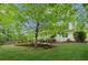 Nice, green backyard with trees and landscaping next to the house at 5705 Twelve Oaks Dr, Cumming, GA 30028