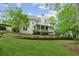 Expansive backyard with green grass, surrounding trees, and the back of the house at 5705 Twelve Oaks Dr, Cumming, GA 30028