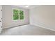 Spacious bedroom with large window, ceiling fan, and plush carpeting offers a comfortable retreat at 5705 Twelve Oaks Dr, Cumming, GA 30028