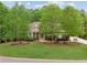 Well-manicured front yard of this charming home, featuring lush greenery and mature trees at 5705 Twelve Oaks Dr, Cumming, GA 30028