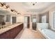 Bathroom featuring granite countertop, dual sinks, tile floor, glass shower door, and soaker tub at 9843 Talisman Dr, Alpharetta, GA 30022