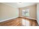 Bedroom features hardwood flooring, a window, and neutral paint at 9843 Talisman Dr, Alpharetta, GA 30022