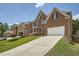 Elegant brick home with a long driveway, attached garage, and lush landscaping for a welcoming curb appeal at 9843 Talisman Dr, Alpharetta, GA 30022
