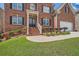 Beautiful brick home with a front porch and meticulously maintained landscaping around the entrance and garage at 9843 Talisman Dr, Alpharetta, GA 30022