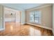 Cozy living room featuring gleaming hardwood floors and ample natural light streaming through a large window at 9843 Talisman Dr, Alpharetta, GA 30022