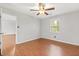 This bedroom features hardwood flooring, a ceiling fan, and a window with natural light at 1181 Mannbrook Dr, Stone Mountain, GA 30083