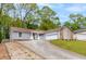 Inviting single-story home features a long driveway and a pristine garage in a serene, tree-lined setting at 1181 Mannbrook Dr, Stone Mountain, GA 30083