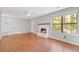 Inviting living room featuring a cozy fireplace, hardwood floors, and large windows for natural light at 1181 Mannbrook Dr, Stone Mountain, GA 30083