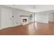 Spacious living room with hardwood floors, a fireplace, and abundant natural light from the large windows at 1181 Mannbrook Dr, Stone Mountain, GA 30083
