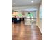 Open dining area with hardwood floors connecting kitchen with white cabinets, island, and stainless appliances at 1907 Shalimar Ne Dr, Atlanta, GA 30345
