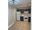 Compact kitchen with dark cabinets, white appliances, tile floor, and modern lighting fixture at 2080 Charter Ln, Lithonia, GA 30058