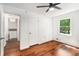 A bedroom featuring hardwood floors, neutral walls, a ceiling fan, and a window providing natural light at 240 Wellington Dr, Mcdonough, GA 30252