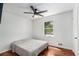 Bright bedroom featuring hardwood floors, a ceiling fan, a window with a pleasant view, and neutral wall color at 240 Wellington Dr, Mcdonough, GA 30252