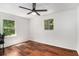 Bright bedroom featuring hardwood floors, a ceiling fan, a window with a pleasant view, and neutral wall color at 240 Wellington Dr, Mcdonough, GA 30252