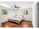 A cozy bedroom featuring hardwood floors, two windows, and a ceiling fan at 240 Wellington Dr, Mcdonough, GA 30252