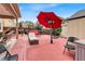 Inviting backyard patio with lounge furniture, covered seating area, and a large red umbrella for shade at 3259 Baylor Cir, Mcdonough, GA 30253