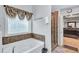 Bathroom featuring a tub with a window and a glass shower door at 3259 Baylor Cir, Mcdonough, GA 30253