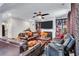 Inviting living room featuring leather furniture, built-in shelving, a fireplace, and modern ceiling fan at 3259 Baylor Cir, Mcdonough, GA 30253