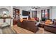 Comfortable living room featuring built-in shelving, cozy leather seating, a fireplace, and a ceiling fan at 3259 Baylor Cir, Mcdonough, GA 30253