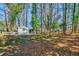 Spacious backyard surrounded by mature trees, offering privacy and a serene setting with an outbuilding at 3406 Jackson Dr, Decatur, GA 30032