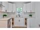 Bright kitchen with white cabinets, modern hardware, quartz countertops, stainless steel appliances, and corner storage at 3406 Jackson Dr, Decatur, GA 30032