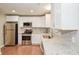 Bright kitchen with stainless steel appliances, white cabinets, granite countertops, and tiled backsplash at 429 Landers Dr, Mableton, GA 30126