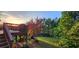 A lovely deck overlooks a spacious backyard, lush with greenery and a beautiful tree at 570 Eldridge Dr, Suwanee, GA 30024