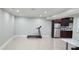 Open basement area with tile flooring, a treadmill, and a kitchenette with stainless steel appliances at 570 Eldridge Dr, Suwanee, GA 30024
