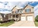 Brick two-story home with a covered front porch, two-car garage, and well-maintained lawn in a residential neighborhood at 570 Eldridge Dr, Suwanee, GA 30024