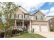 Charming two-story home with a welcoming front porch, brick facade, and a convenient two-car garage, all set on a green lawn at 570 Eldridge Dr, Suwanee, GA 30024