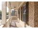 A close-up view of the covered front porch that features white columns and railings and a stained wood deck at 570 Eldridge Dr, Suwanee, GA 30024