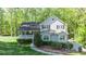 Beautiful two-story home with light blue siding, black shutters, and lush landscaping at 619 Stoney Creek Rd, Woodstock, GA 30188