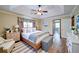 Comfortable main bedroom featuring tray ceilings, hardwood floors, and abundant natural light at 619 Stoney Creek Rd, Woodstock, GA 30188