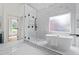 Luxurious bathroom with standalone tub, glass-enclosed shower, marble-look tile, and modern black fixtures at 1749 Patriots Nw Way, Kennesaw, GA 30152