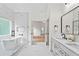 Bright bathroom featuring standalone tub, glass shower, double vanity, light marble tile, and modern black fixtures at 1749 Patriots Nw Way, Kennesaw, GA 30152